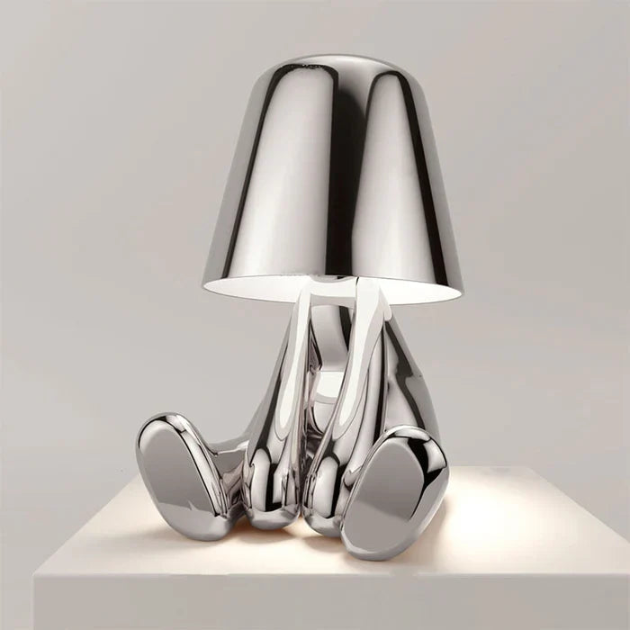 Designerska lampa stołowa LED — figurka w pozycji siedzącej, połyskujące wykończenie | Norivo Norivo